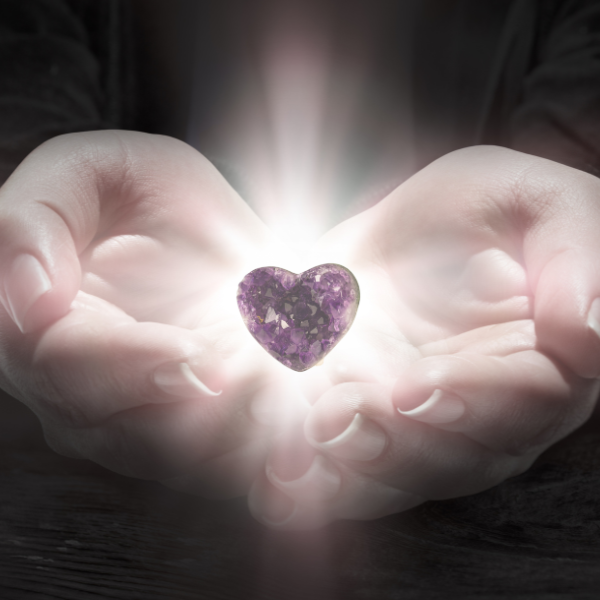 Hands holding a heart-shaped crystal, symbolizing compassion, emotional support, and heart-centered cleaning services in Salt Lake City